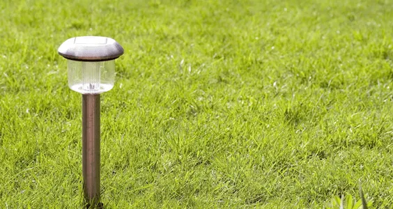 Outdoor path light standing in a green lawn